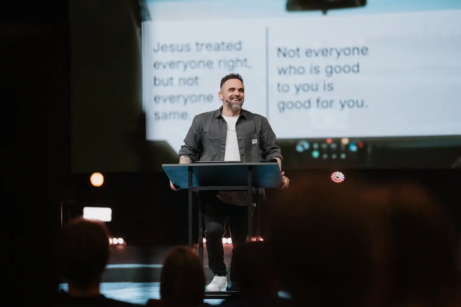 Pastor David Eiffert teaching on stage with the message slide behind him