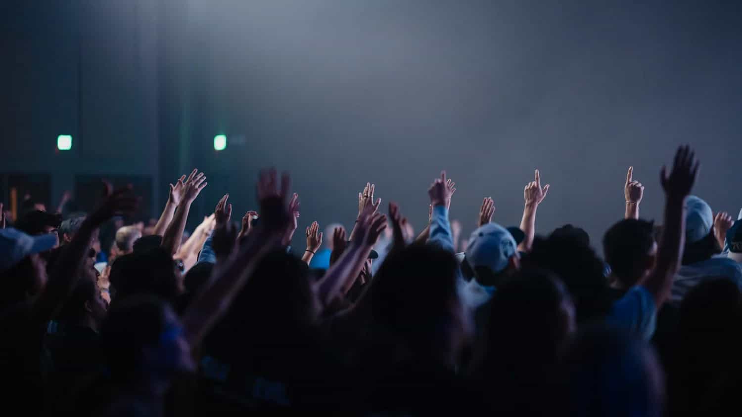 Congregation raising their hands together during worship