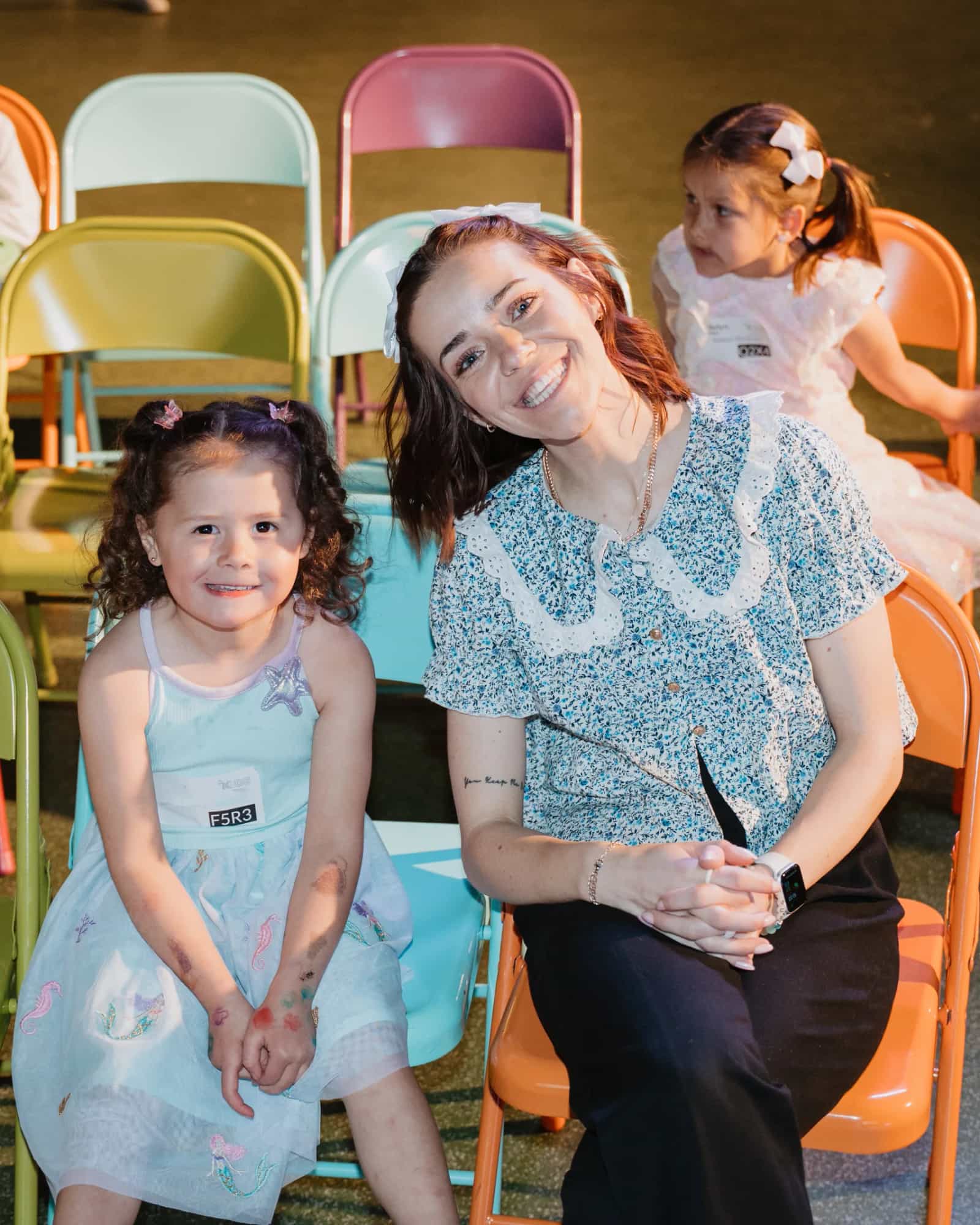 BC Kids leader sitting with two young girls in colorful chairs